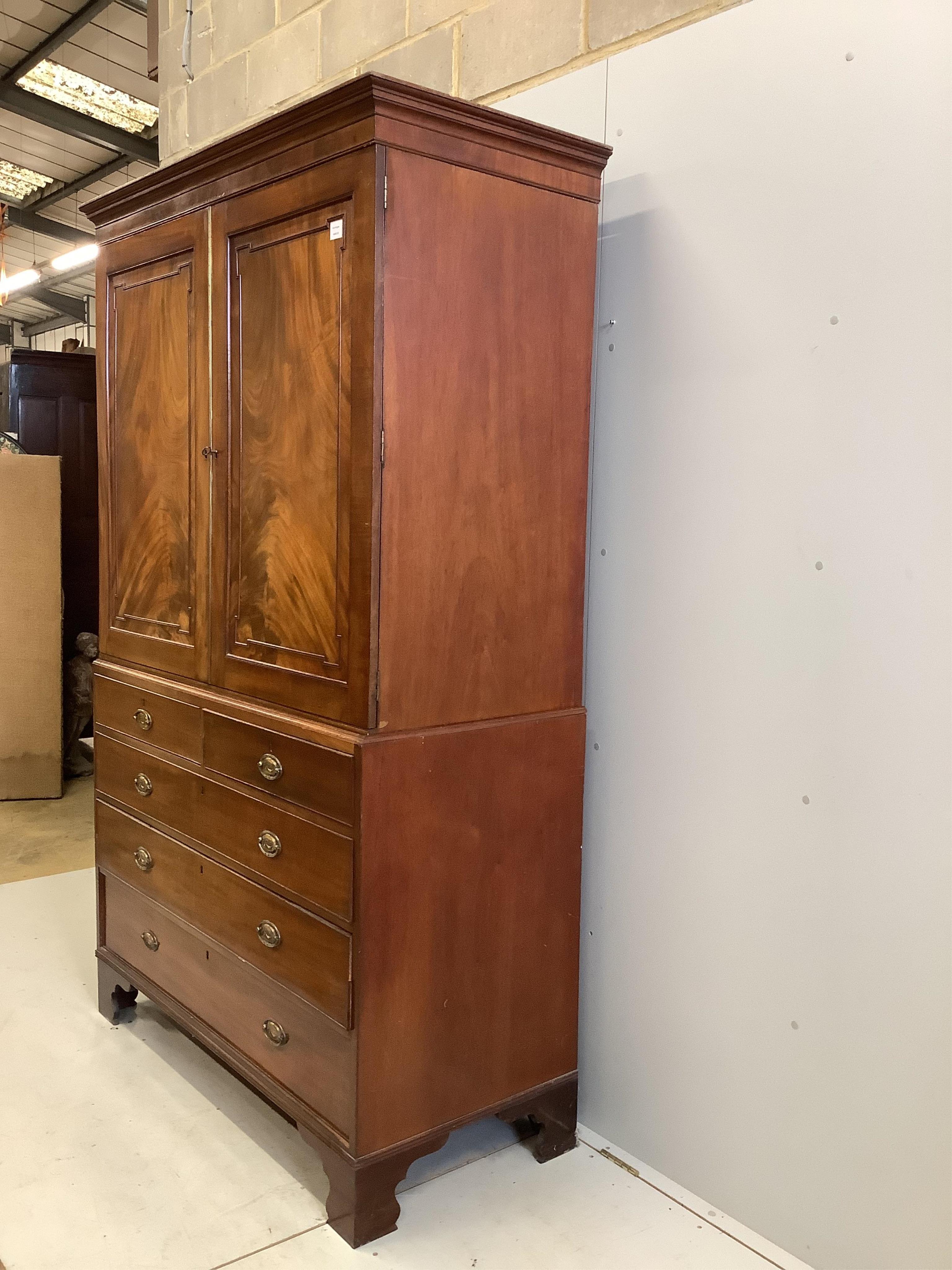 A George III mahogany linen press, converted to hanging cupboard, width 130cm, depth 58cm, height 215cm. Condition - fair, sliding trays deficient